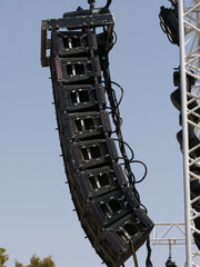 Line array speaker system, they consist of several smaller speaker boxes stacked vertically on top of each other, with each box containing several small speakers.