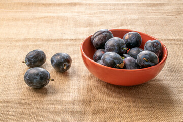 Sweet black plum on jute cloth, macro.