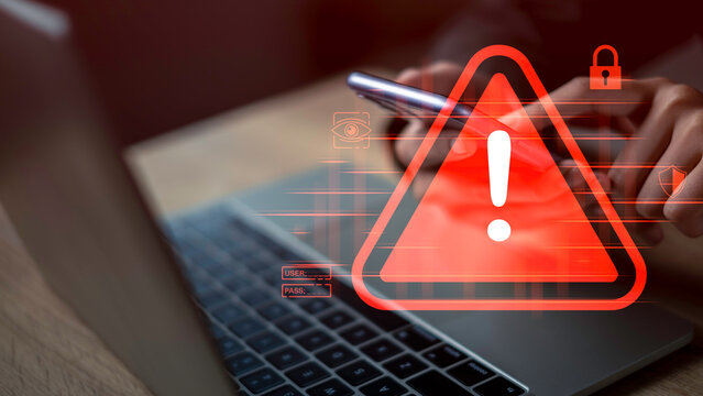 Cybersecurity warning concept showing red alert symbol on digital devices, representing protection against malware, phishing attacks, data breaches, hacking, and other online cyber crime threats.