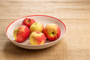 Sweet red apples on jute cloth, macro.