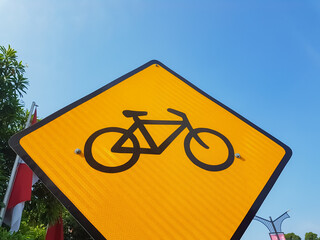 Yellow Bicycle Warning Sign against Clear Blue Sky