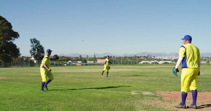 Man diving after fly ball in uniform in outfield, intercepting and tossing to baseman, copy space