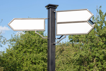 Signpost arrows with copy space against cloudy blue sky