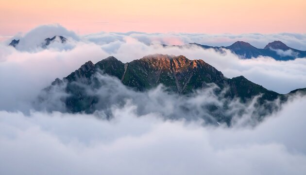 Mountain peaks rising above a sea of clouds at dawn