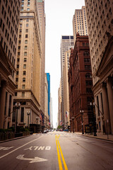 Obraz premium Urban street view of downtown Chicago with skyscrapers, historic architecture, empty road, American flags, financial district, travel and business cityscape.