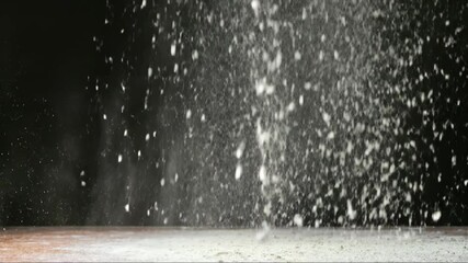 Falling flour dust over wooden table forms soft mound rustic kitchen scene warm light food styling baking concept recipe background for ads menus packaging 
