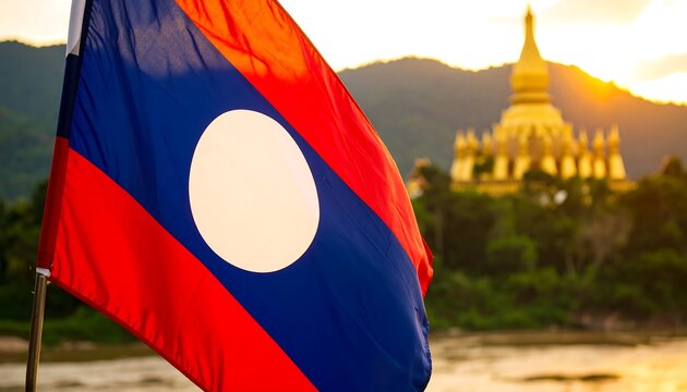 Laotian flag waving in sunset over temple
