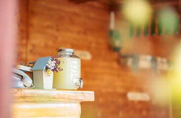 A rustic lemonade stand offers a refreshing drink on a late summer afternoon. A vintage telephone and small birdhouse decorated with fresh flowers add nostalgic charm to the scene