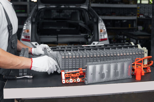 Serviceman repairs electric battery pack of hybrid car