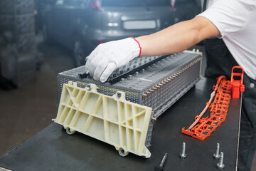 Serviceman repairs electric battery pack of hybrid car