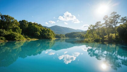 Obraz premium Bright sunny day over a calm lake, reflecting lush green trees and clear blue sky with fluffy clouds. Sunlight sparkles on the water surface, creating a peaceful, scenic natural landscape.