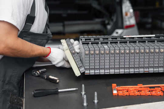 Serviceman repairs electric battery pack of hybrid car