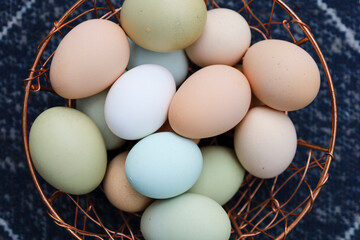Organic eggs of different colors in the metal basket