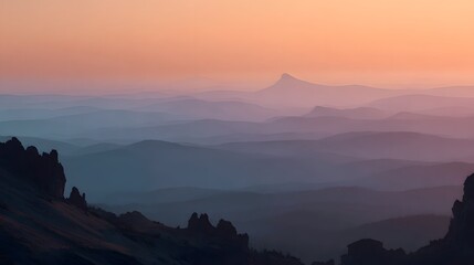 Obraz premium A serene vista of layered mountains bathed in a pastel sunrise, showcasing a tranquil landscape with soft color gradients.