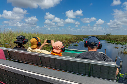 Tourists with headsets in an ariboat, Everglades touristic airboat ride and tour, Florida