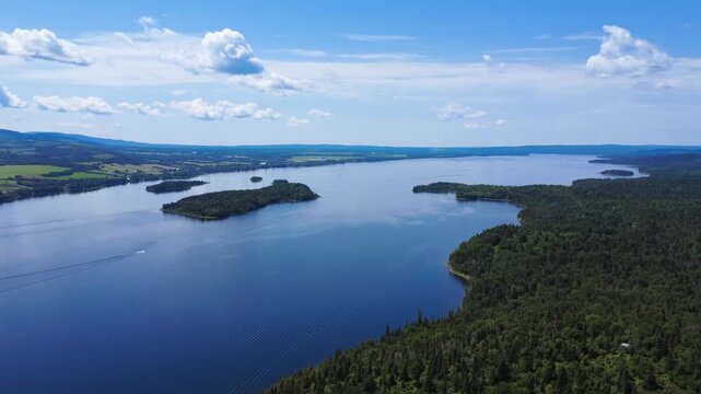 Panoramic aerial view of Lake Matapedia at the edge of the untouched forest of the Seigneurie du Lac Matapedia. Quebec, Canada. 2025.