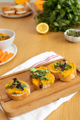 Healthy autumn snack with pumpkin spread and seed topping on wooden board. Pumpkin hummus
