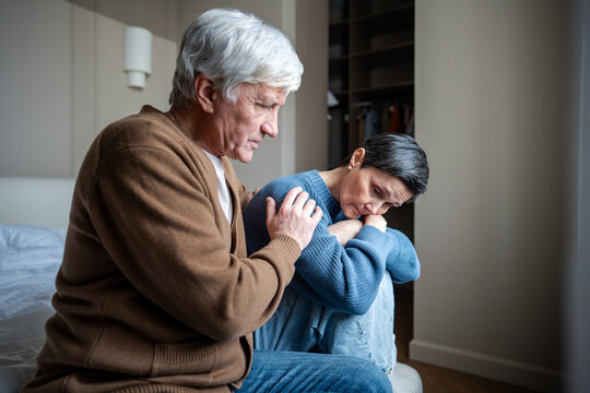 Elderly couple in grief and depression, man comforting woman with mental health struggles on bed. Bipolar disorder support, emotional distress, mutual vulnerability, calming embrace, care partnership - Powered by Adobe