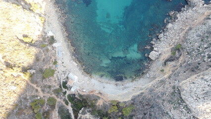 Panoramic view of a coastal city with modern buildings, sandy beach and clear blue sea under a bright sunny sky