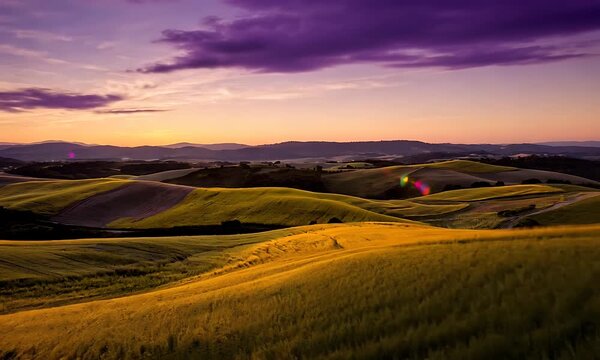 Dramatic Golden Sunset Over Undulating Green and Gold Fields with Purple Sky and Distant Mountains
