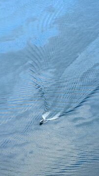 Aerial view of a speedboat drving by sapphire blue water at Geirangerfjord, Norway, travel experience