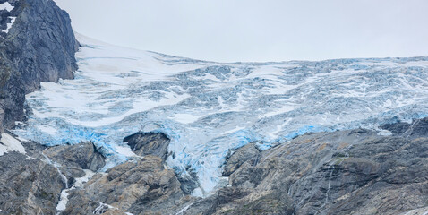 the detail of blue glacier up in the rocky mountain at Tuftebreen, Norway summer
