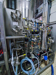 Wine production. Stainless steel industrial process equipment on a winery plant. Modern manufacturing system for food and beverage production. Bio vine industry. Production room at winemaking factory.