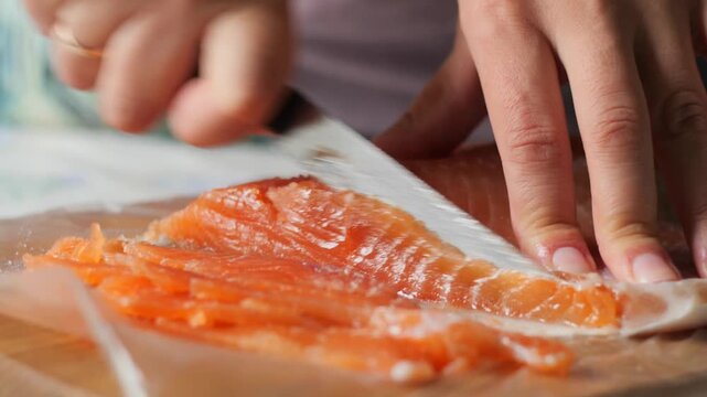 Hands slicing a salmon fillet