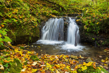 Waterfall cascading over rocks in autumn forest in Haj, Slovakia
