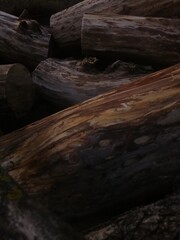  The logs are stacked on top of each other. Firewood with and without bark, with a wavy pattern. Firewood brown, black, light 