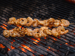 shrimp skewers sizzling over hot charcoal embers on a barbecue grill