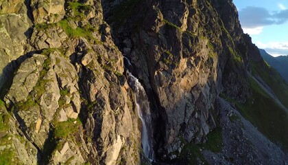Mountain waterfall, sunlight highlights
