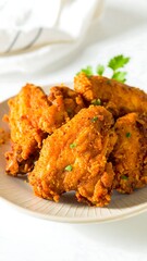 Crispy, golden-brown fried chicken wings on a plate, garnished with parsley