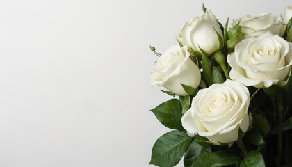 Fototapeta premium Close-up of natural white rose bouquet against a white backdrop. This charming floral arrangement features blooming roses with green leaves, perfect for weddings, celebrations, or invitations.