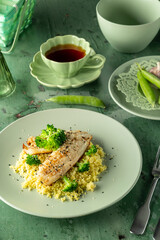 Delicious grilled fish fillet seasoned with black sesame seeds, served with broccoli and couscous