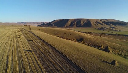 Fototapeta premium High-angle view of a rural landscape with hills and harvested fields