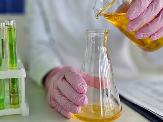 Scientist conducting an experiment with yellow liquid in laboratory
