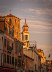 Venetian street with colorful houses and bell tower in Venice Italy