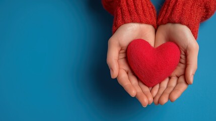 Fototapeta premium Hands Holding Red Heart Shape on Blue Background for Love Concept