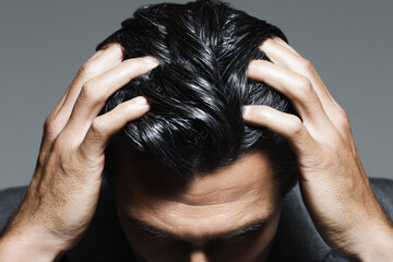 Fototapeta premium Modern Brunette Man Headshot Showing Stress Anxiety With Hands Black Studio Background Emphasizing Emotions Male Grooming Sad Expression Neat Well-Groomed Haircare Fashion Relaxed Yet Tense Look