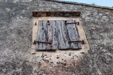 Weathered Wooden Shutters on an Old Stone Wall