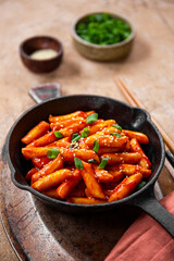 Korean street food, tteokbokki with sesame in the fried pan vertical photo