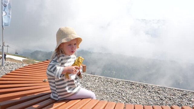 A three-year-old child girl travels in the mountains in the summer, pictured alone, Rosa Khutor, Sochi