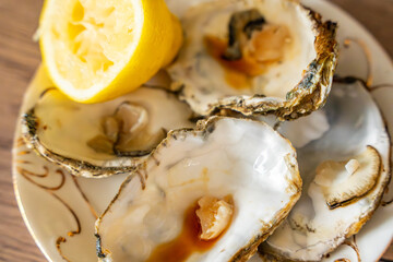 Empty oyster shells with lemon remains and sauce traces on a kitchen surface. Scene after eating seafood at home.