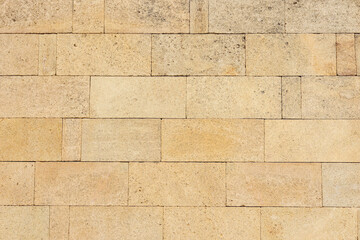 Yellow brick wall texture. House stone wall texture background. Stone wall as background or texture. Part of a stone wall.  Ideal for backgrounds, textures, and construction-related