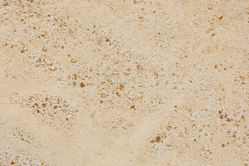 Close-up beige brick wall texture. House stone wall texture background. Stone wall as background or texture. Part of a stone wall.  Ideal for backgrounds, textures, and construction-related