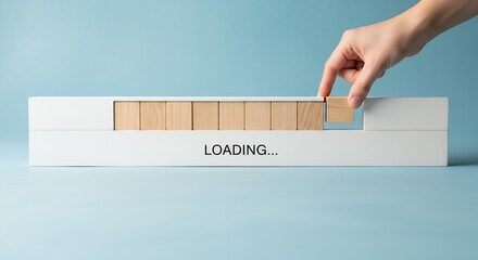 Hand places wooden block completing a loading bar with LOADING text Progress Completion Process Blocks Building Technology Waiting Update Data Information