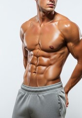 Fototapeta premium Muscular man with sixpack abs glistening skin wearing grey sweatpants