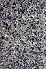 Rough granite stone texture with multicolored mineral grains of pink, black and gray colors