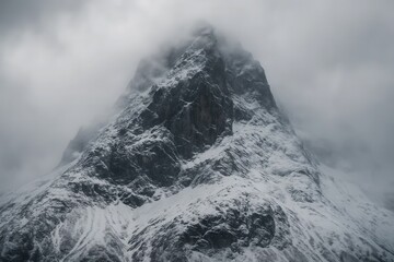 A Glimpse into the Sublime Beauty of a Snow-Capped Mountain Peak in the Throes of a Foggy Embrace